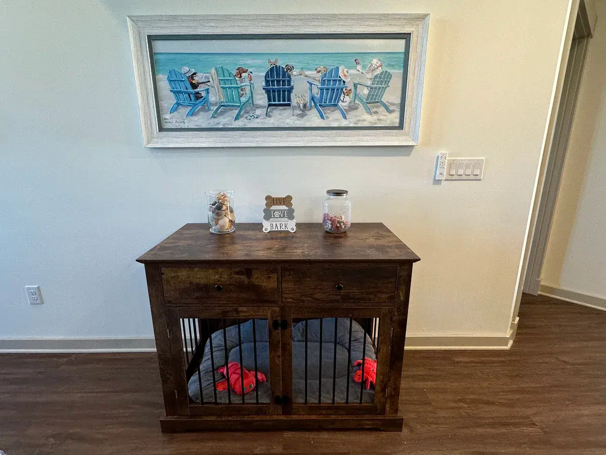 Stylish dog crate furniture with beach-themed art above at Grandy Cove